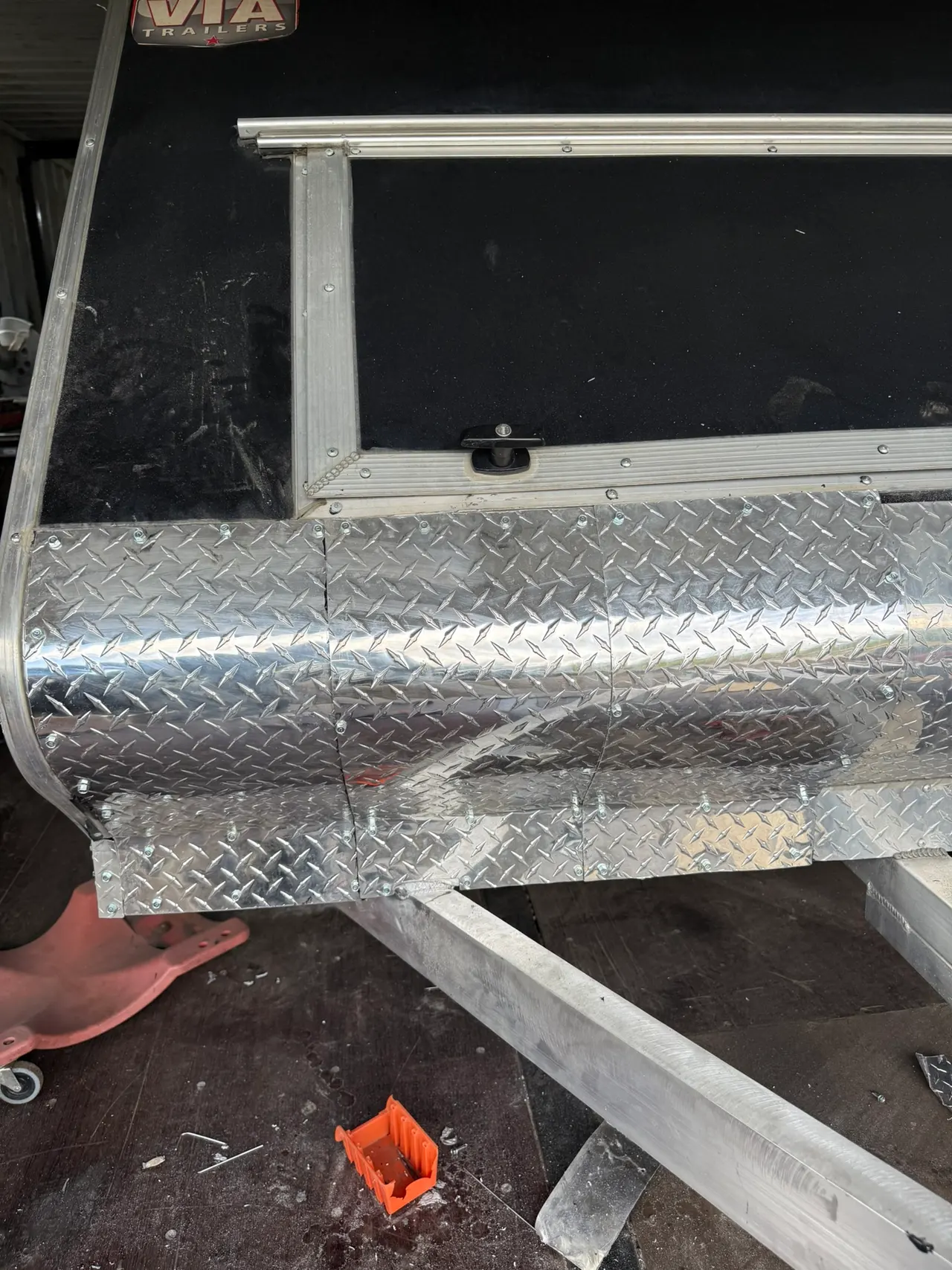 Front corner of a fabricated trailer body with diamond plate panels