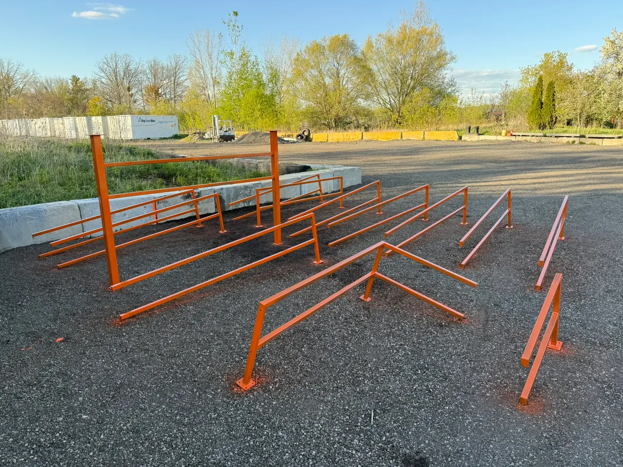Orange rectangular steel handrail sections arranged outside before installation